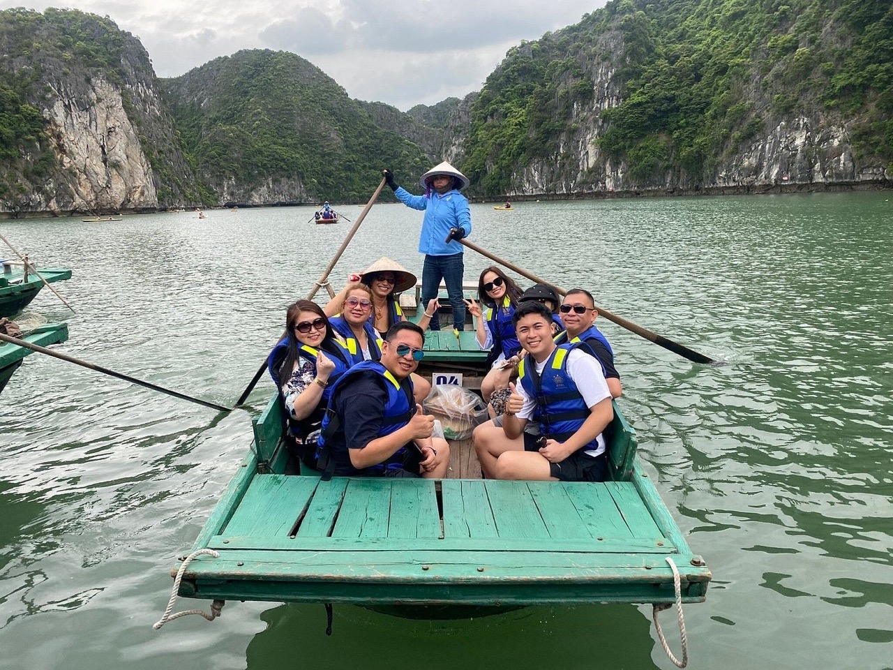 Boat tour in Halong Bay with tourists enjoying the scenic landscape and limestone karsts.