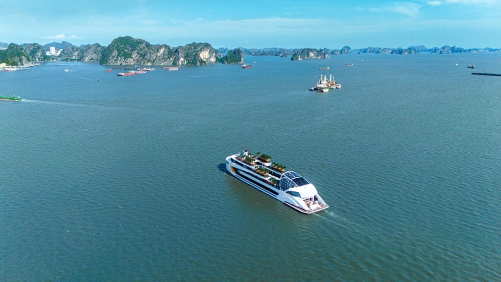 Luxurious cruise sailing in Ha Long Bay with scenic limestone islands.