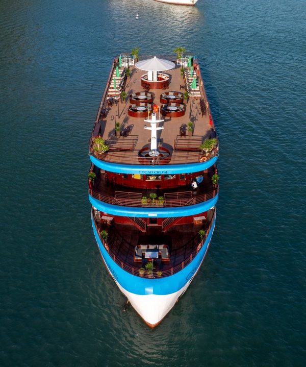 Aerial view of a luxurious cruise boat sailing through Halong Bay's emerald waters, showcasing sceni.