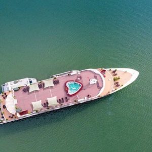 Luxury yacht with a pool on the deck in emerald green waters.