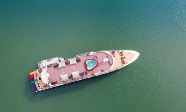 Luxury yacht with a pool on the deck in emerald green waters.