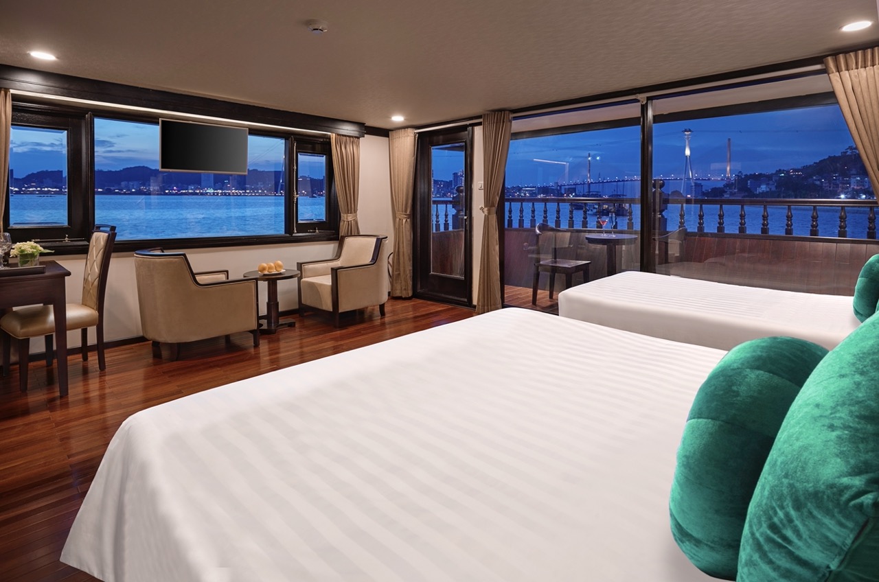 Luxury cruise room with panoramic bay view, modern decor, and spacious balcony, perfect for relaxing.