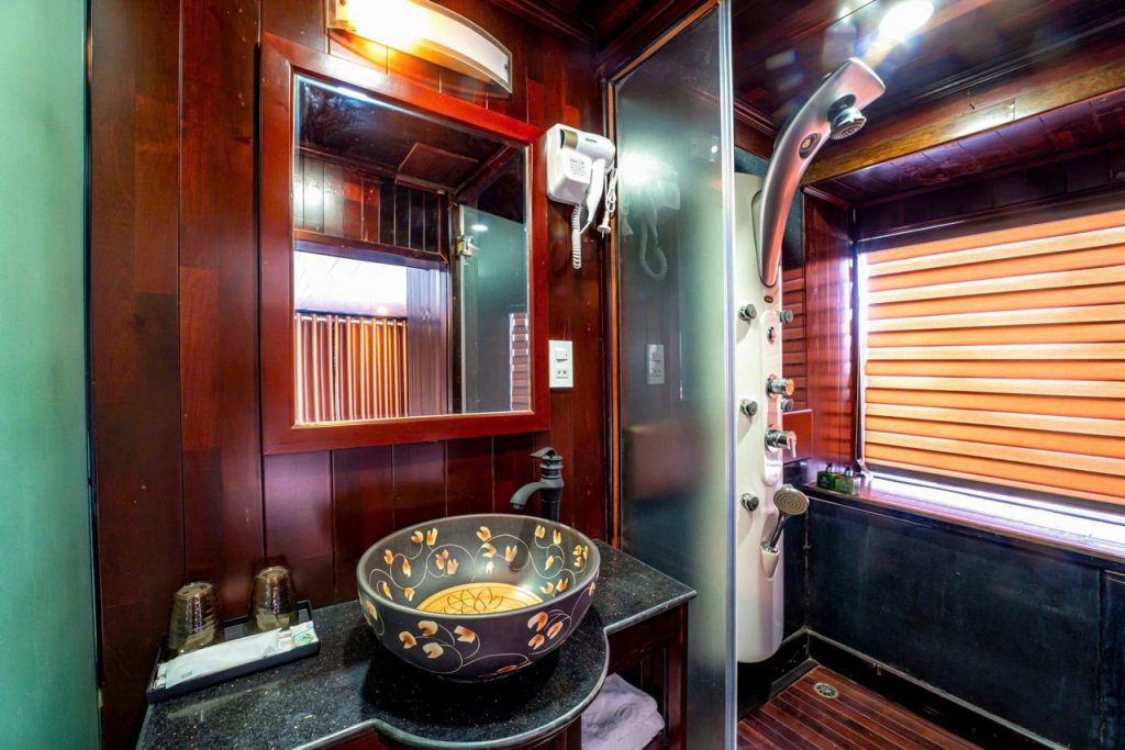 Luxurious Halong Bay cruise bathroom with modern amenities and elegant wooden accents.