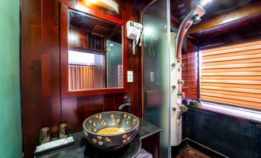 Luxurious Halong Bay cruise bathroom with modern amenities and elegant wooden accents.