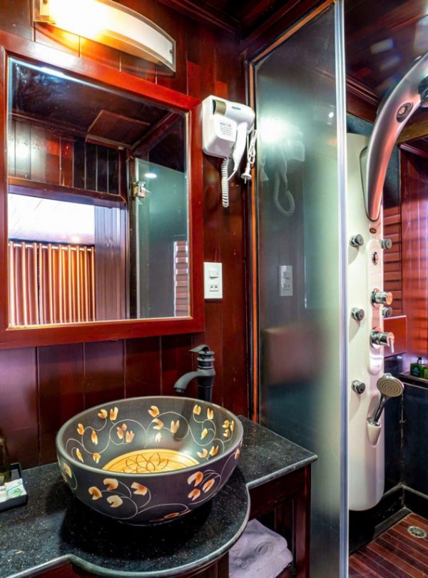 Luxurious Halong Bay cruise bathroom with modern amenities and elegant wooden accents.