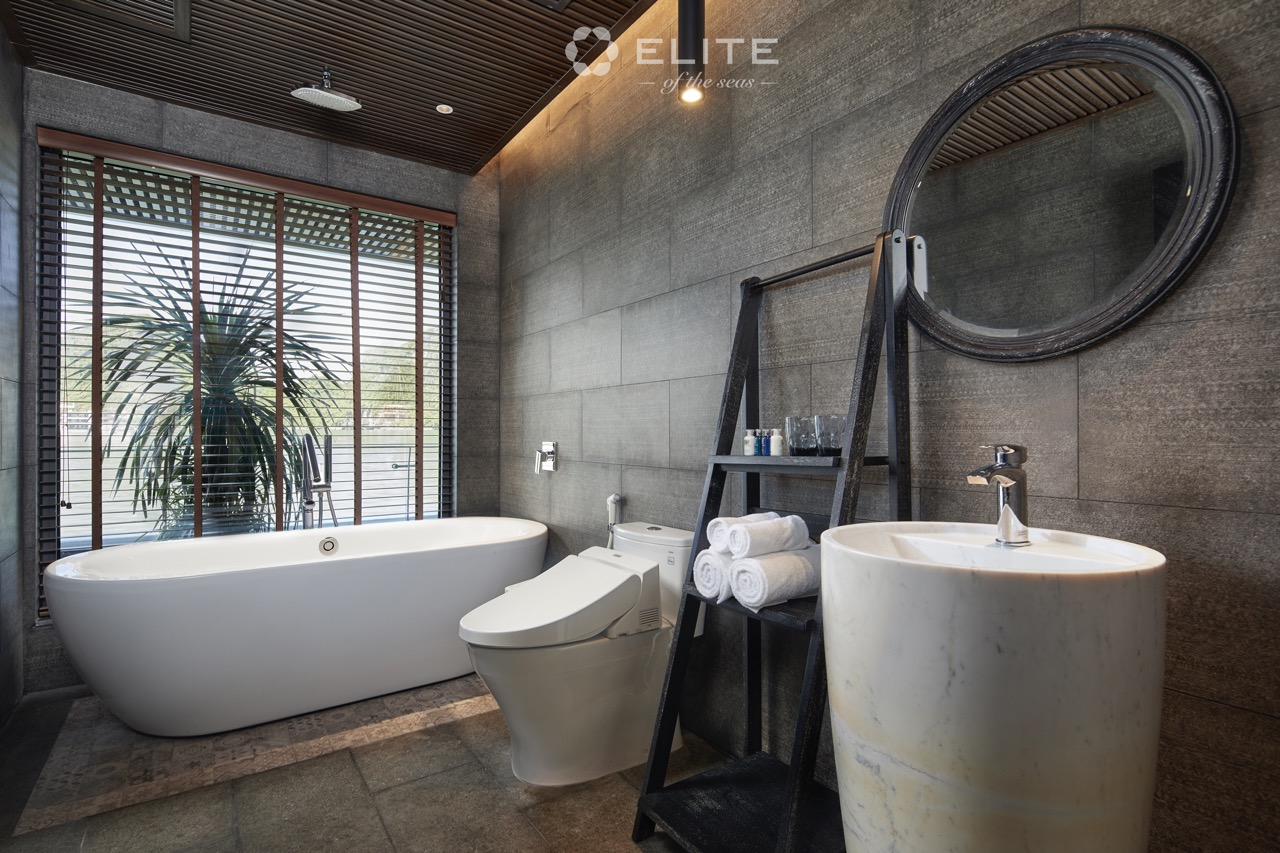 Luxurious cruise bathroom with modern amenities and scenic view of Halong Bay.