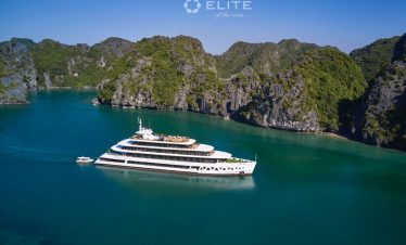 Stunning view of a luxury cruise sailing through Halong Bay's emerald waters with towering limestone.