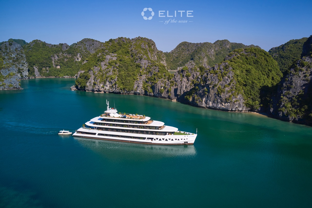 Stunning view of a luxury cruise sailing through Halong Bay's emerald waters with towering limestone.