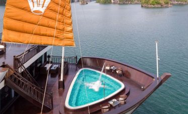 Stunning view of Halong Bay from a cruise balcony, showcasing limestone karsts and tranquil waters,.