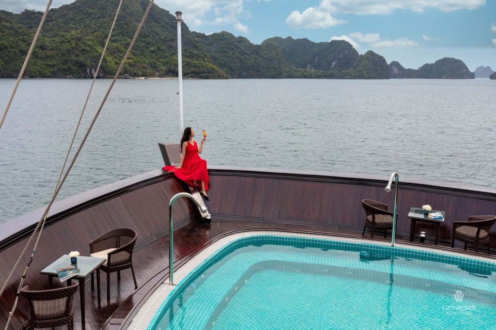 Stunning view of Halong Bay from a cruise balcony with a woman enjoying the scenery and relaxing atm.