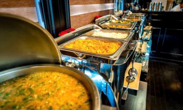 Vibrant buffet spread on a cruise in Halong Bay, showcasing delicious local dishes and scenic views.