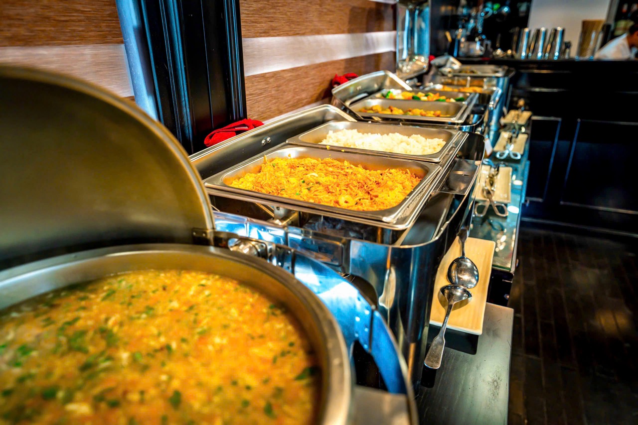Vibrant buffet spread on a cruise in Halong Bay, showcasing delicious local dishes and scenic views.