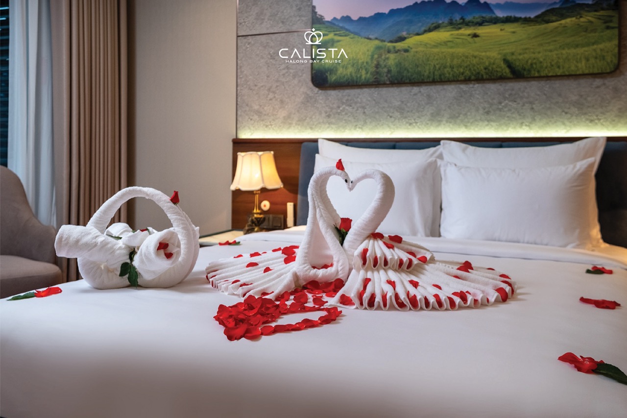 Romantic scene of a luxury Halong Bay cruise with towel art and rose petals, perfect for a memorable.