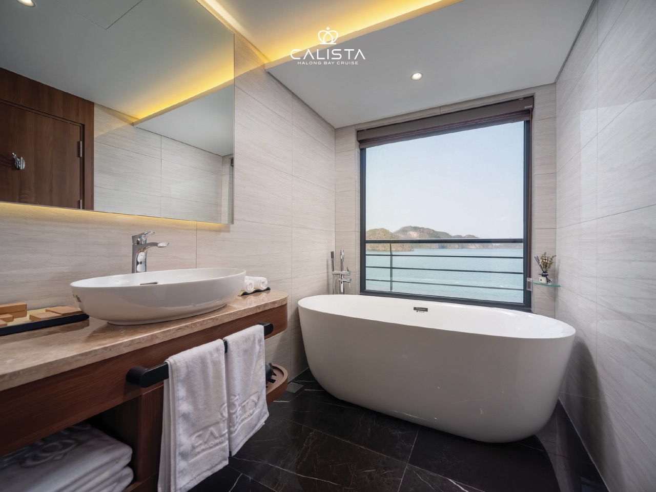 Stunning cruise balcony view of Halong Bay with modern bathroom and ocean scenery.