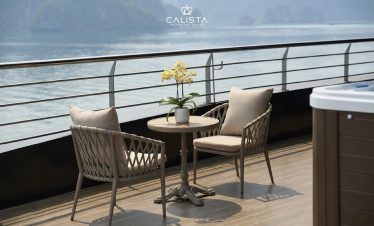 Elegant cruise balcony overlooking Halong Bay with comfortable seating and scenic views.