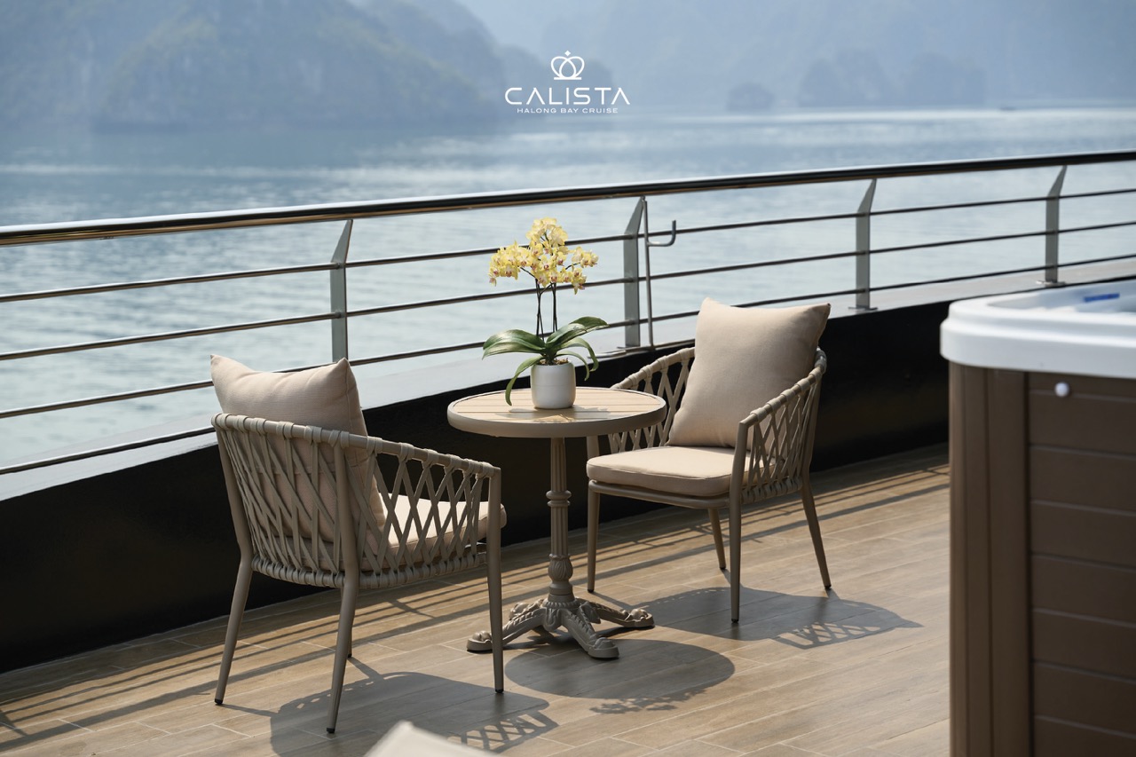 Elegant cruise balcony overlooking Halong Bay with comfortable seating and scenic views.