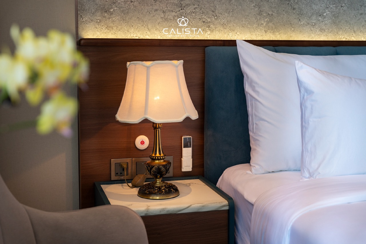 Luxurious cruise bedroom with soft lighting and premium bedding, perfect for a relaxing Halong Bay e.