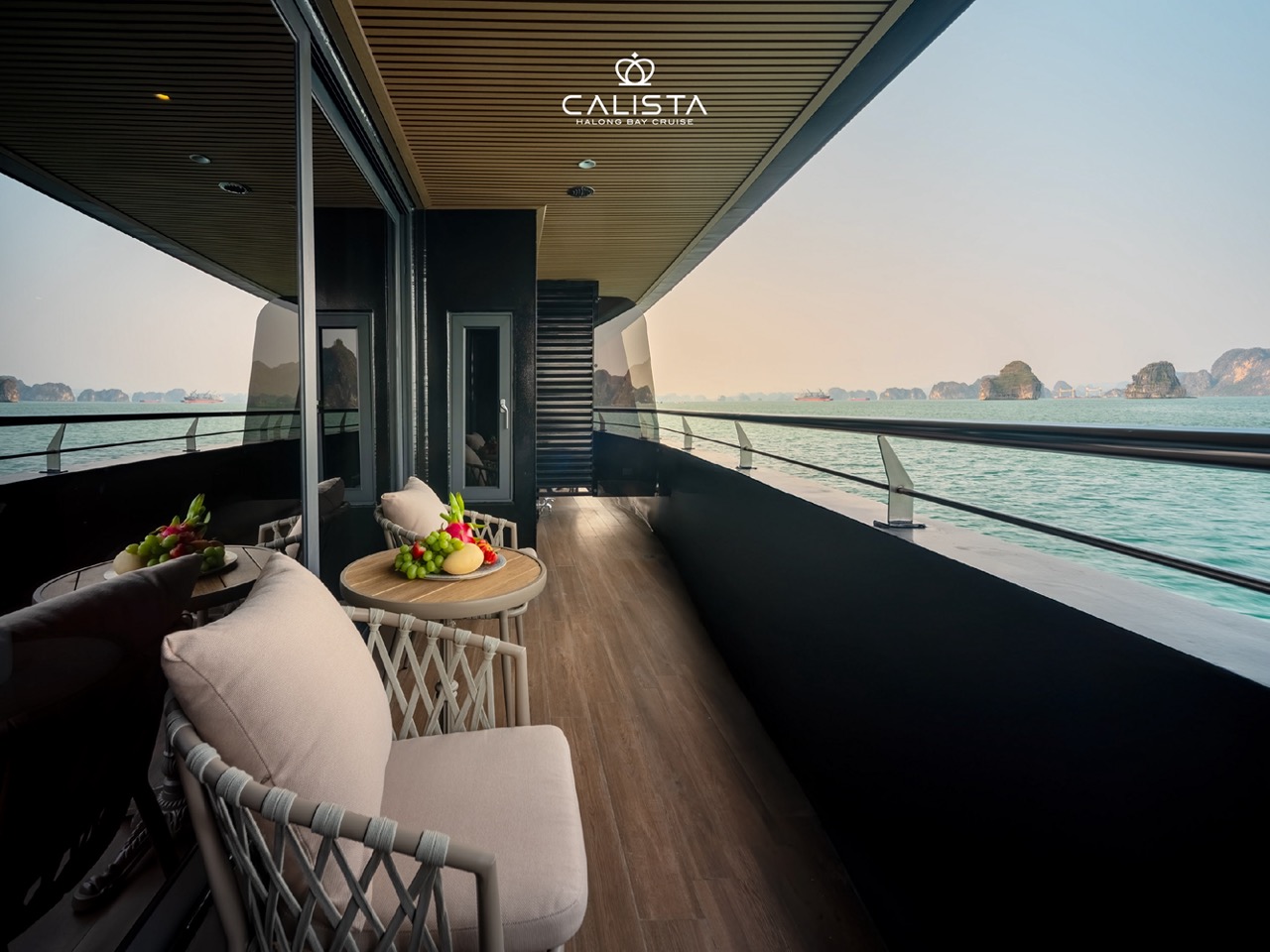 Relaxing cruise balcony view over Halong Bay with stunning sunset scenery.