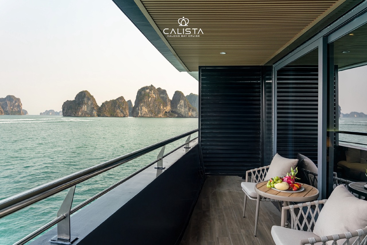 Stunning view from a luxury cruise balcony in Halong Bay, showcasing emerald waters and limestone ka.