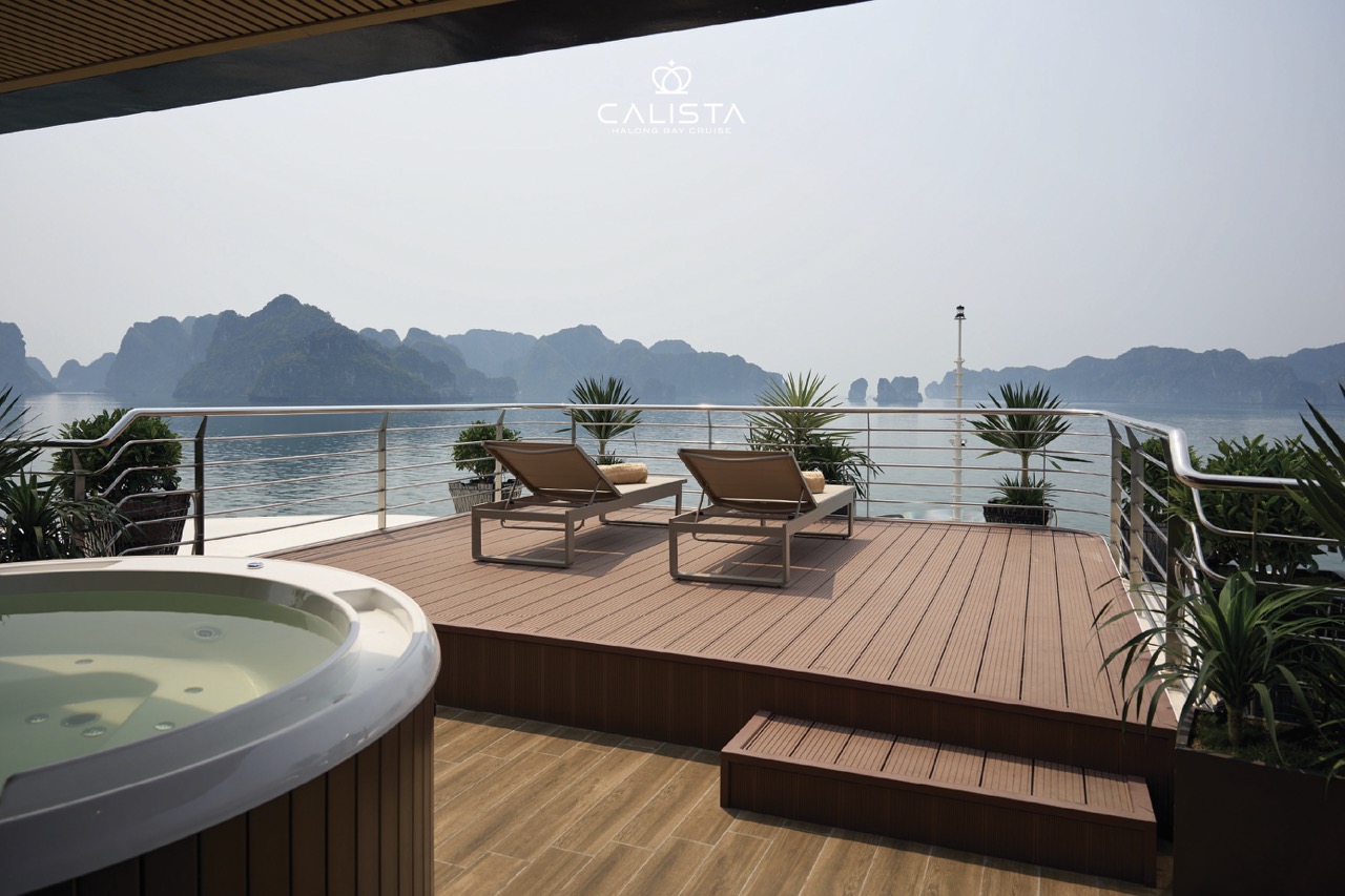 Stunning view from cruise balcony overlooking Halong Bay's limestone karsts and calm waters.