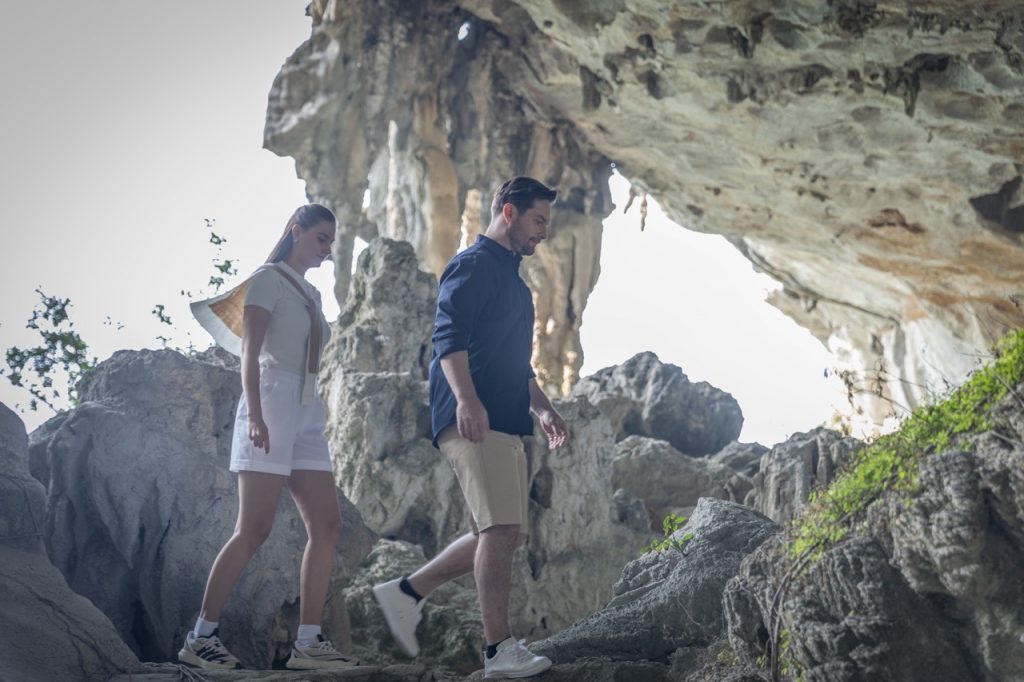 Exploring Halong Bay caves with travelers on a scenic cruise balcony.