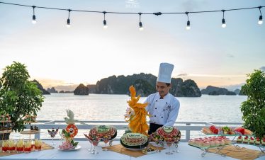 Chef preparing traditional dishes on the deck of Treasure Junk cruise in Bai Tu Long Bay, Vietnam.