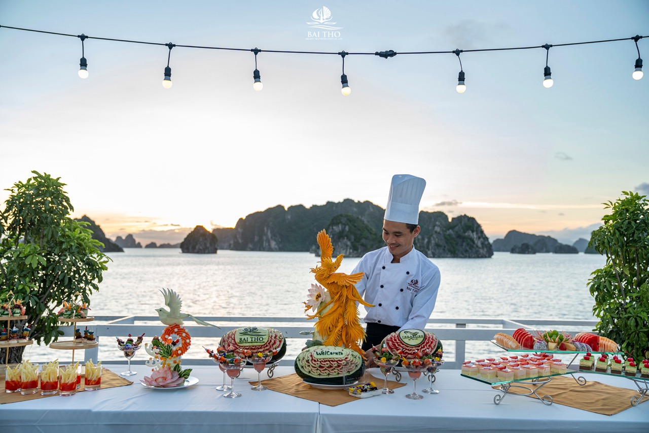 Chef preparing traditional dishes on the deck of Treasure Junk cruise in Bai Tu Long Bay, Vietnam.
