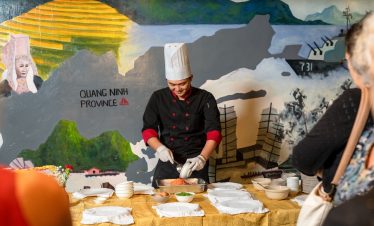 Beautiful scene of a chef preparing local dishes on a cruise in Halong Bay, showcasing authentic Vie.