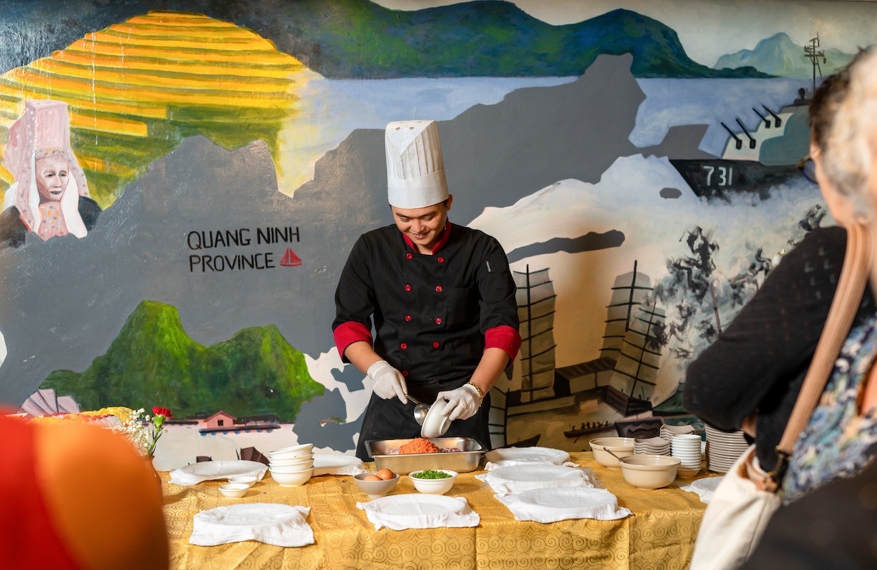 Beautiful scene of a chef preparing local dishes on a cruise in Halong Bay, showcasing authentic Vie.