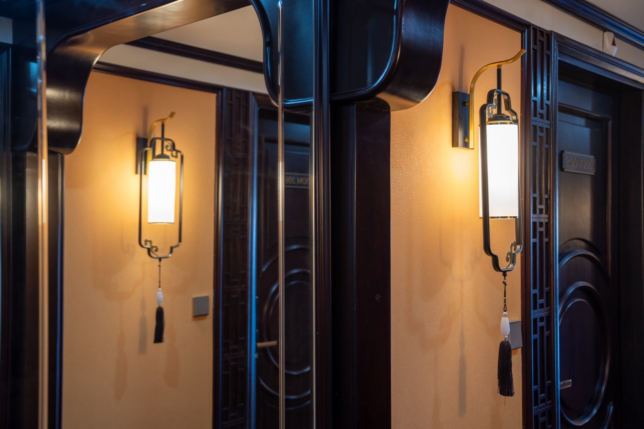 Interior lighting on Bai Tu Long cruise with traditional design and warm ambiance.