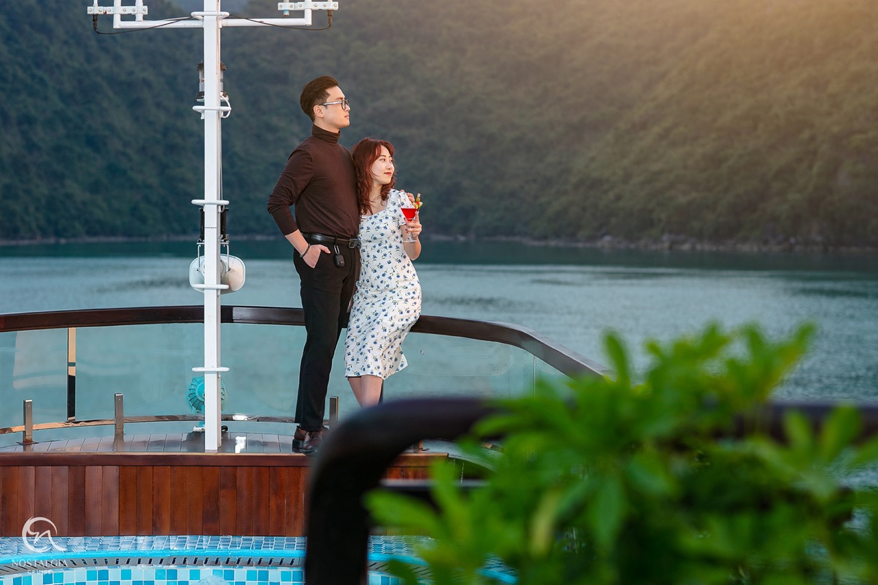 Romantic couple enjoying scenic view from cruise balcony in Halong Bay, Vietnam.
