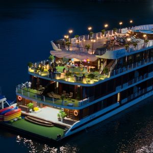 Luxurious dinner cruise boat on the river at night with scenic lighting and outdoor deck, Vietnam travel experience.