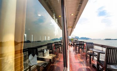 Stunning view from a cruise balcony in Halong Bay, showcasing tranquil waters and scenic limestone k.