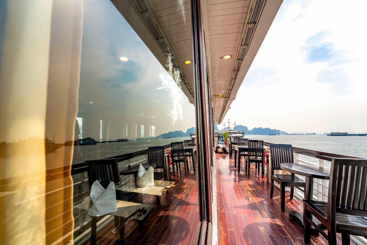 Stunning view from a cruise balcony in Halong Bay, showcasing tranquil waters and scenic limestone k.