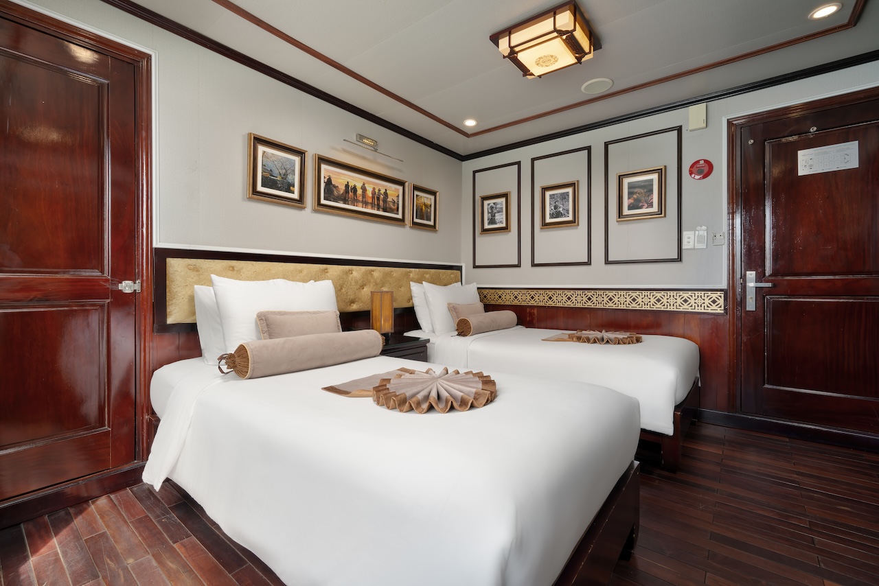 Luxurious cruise cabin with elegant decor and comfortable beds in Halong Bay. Perfect for a memorabl.