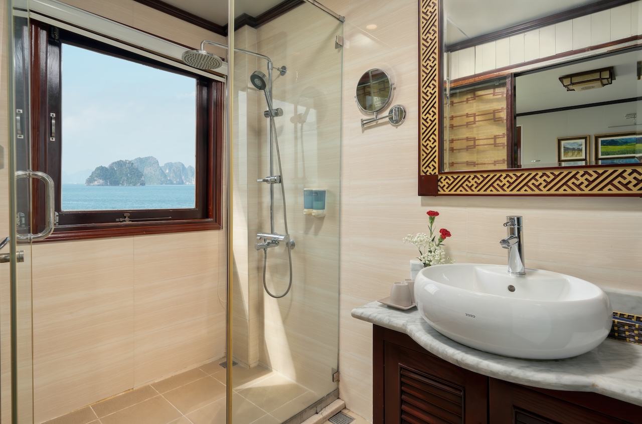 Stunning view from the cruise balcony overlooking Halong Bay's emerald waters and limestone islands.