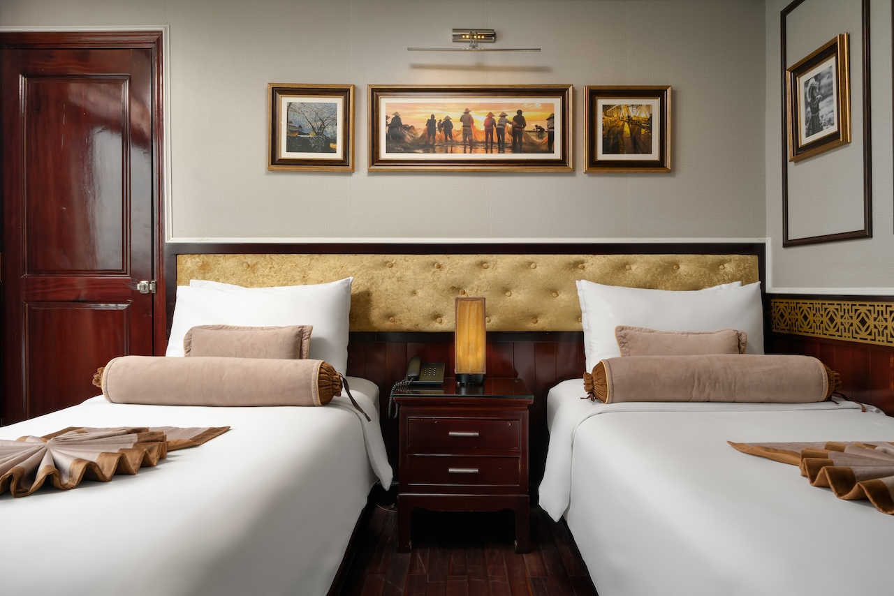 Beautiful cruise cabin interior with plush beds and tasteful artwork, perfect for a relaxing Halong.
