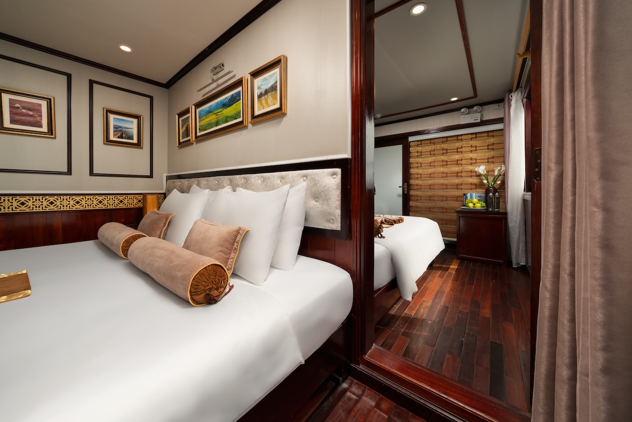 Comfortable cruise room featuring plush bedding and modern decor, perfect for a relaxing Halong Bay.