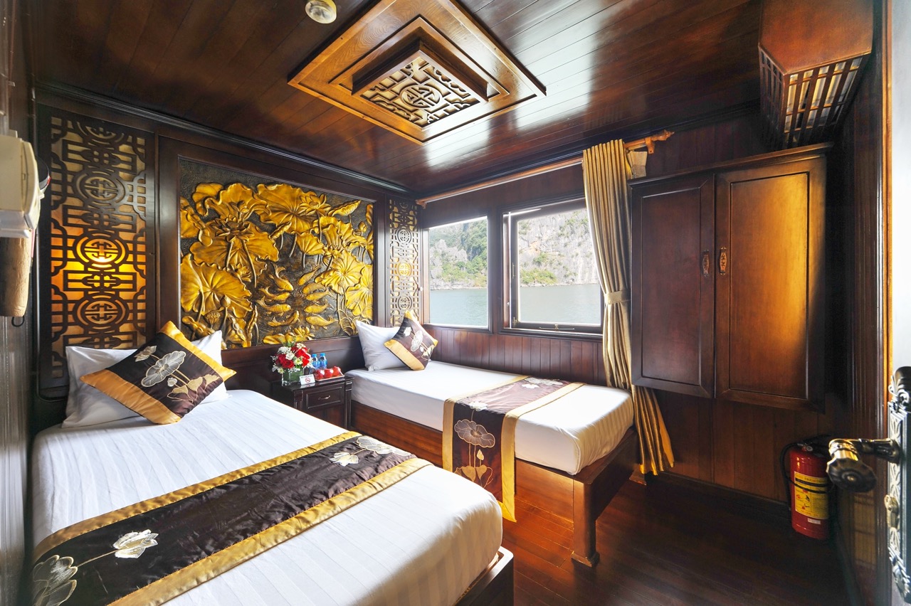 Luxurious cruise cabin with elegant decor overlooking Halong Bay, perfect for a memorable voyage.
