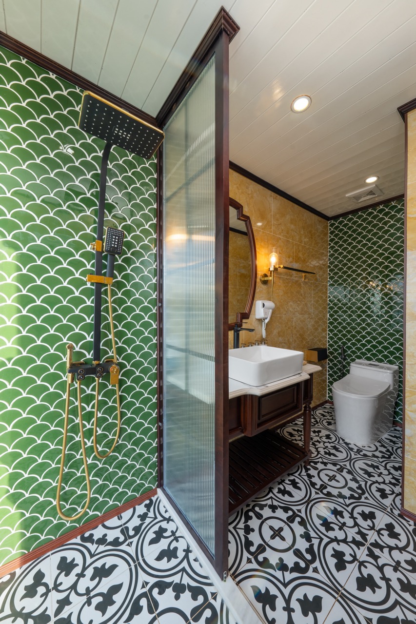 Modern bathroom with elegant green tile accents and stylish fixtures on Bai Tu Long Cruise.