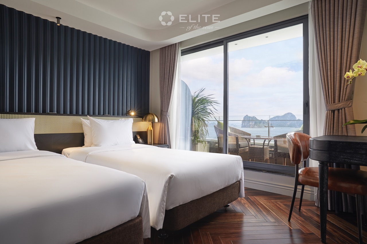 Stunning view from a luxury cruise balcony overlooking Halong Bay with clear skies and calm waters.