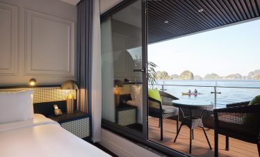 Stunning view from a cruise balcony in Halong Bay, featuring calm waters and limestone islands, perf.