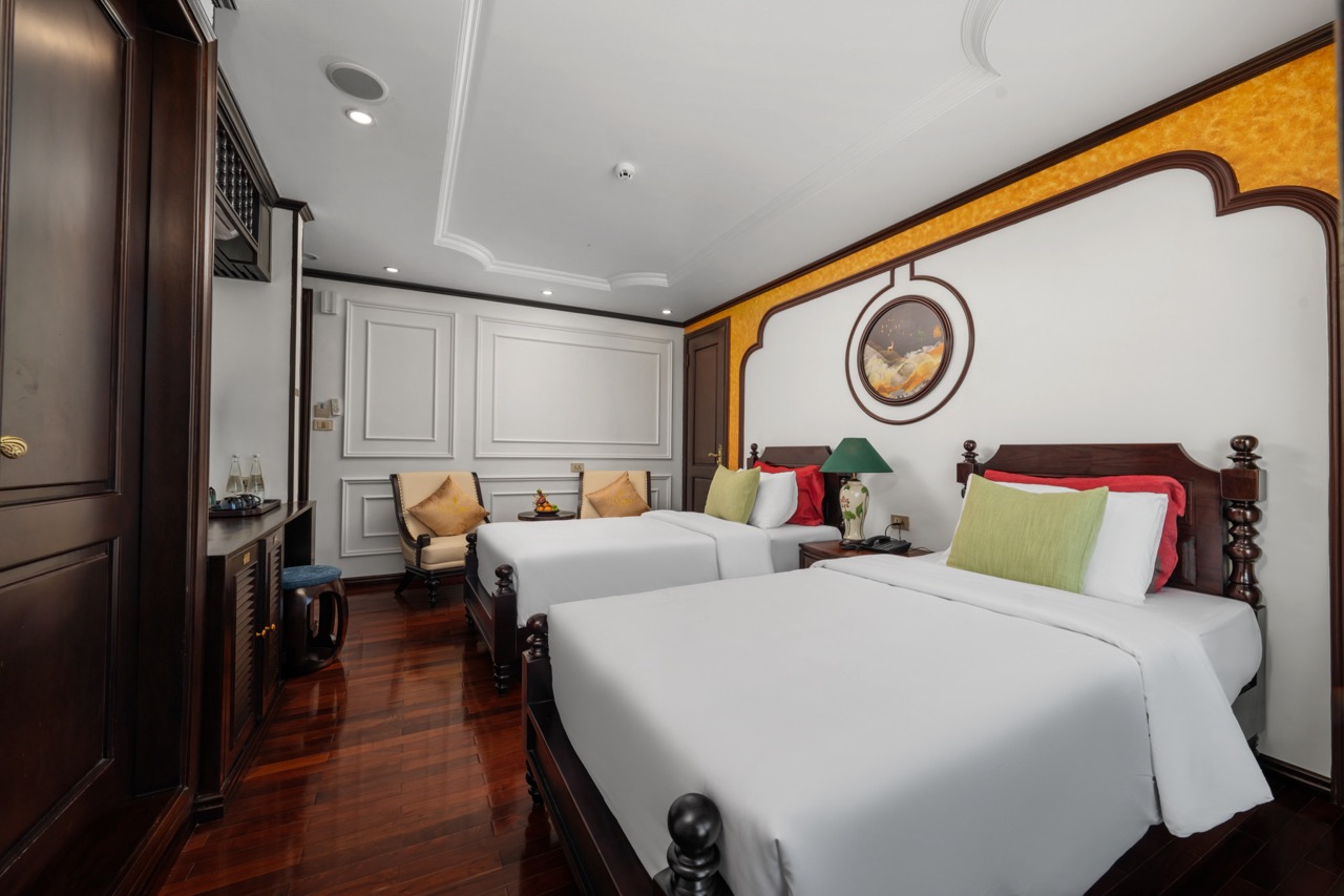 Luxurious cruise balcony room in Bai Tu Long Bay with elegant decor and comfortable beds.