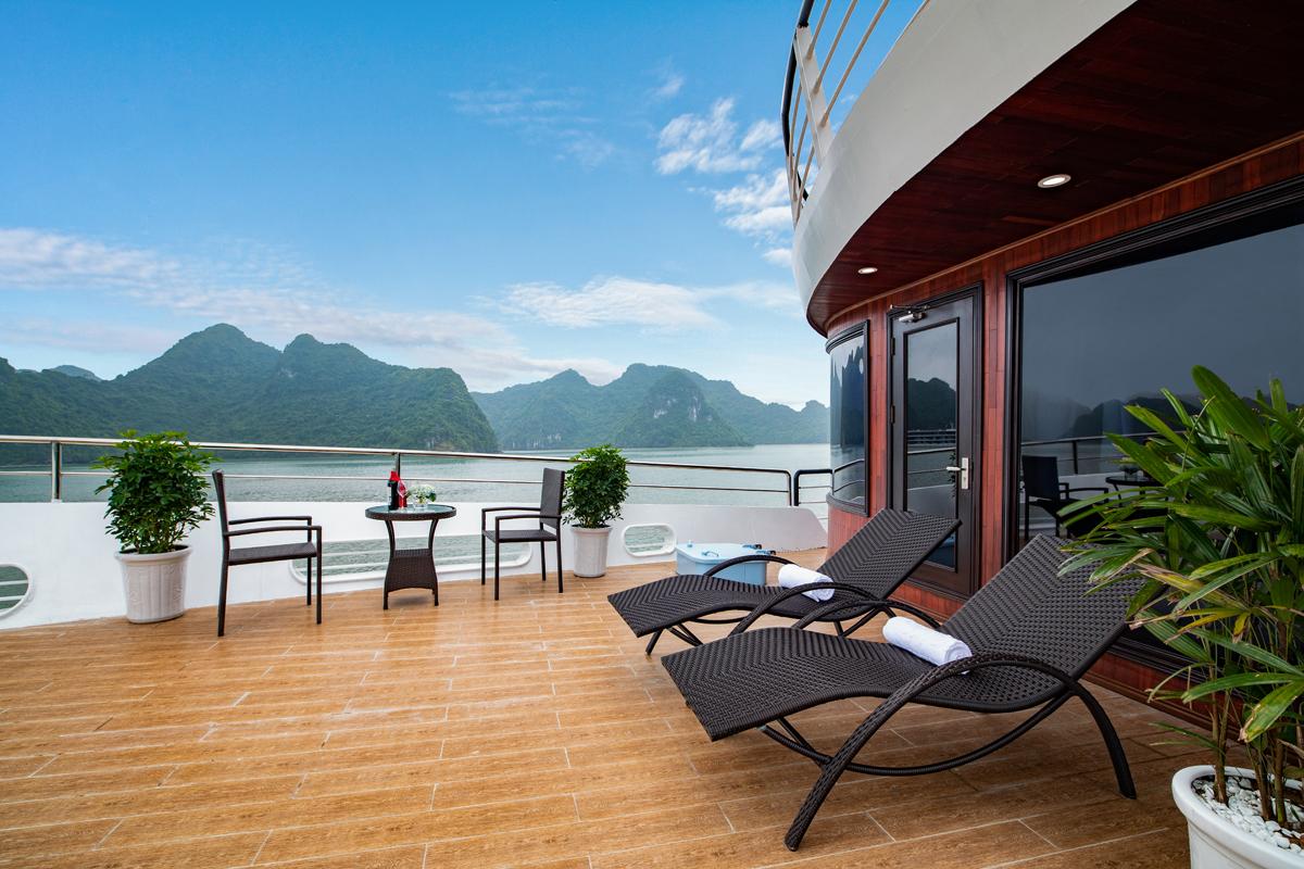 Stunning cruise balcony with mountain view, outdoor seating, and tropical plants for a perfect vacation.