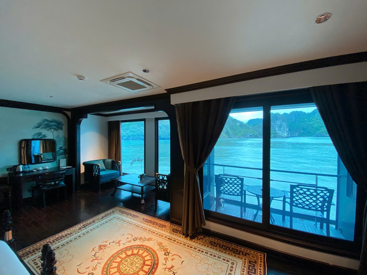Stunning view of Halong Bay from a cruise balcony with elegant interior, perfect for a relaxing geta.
