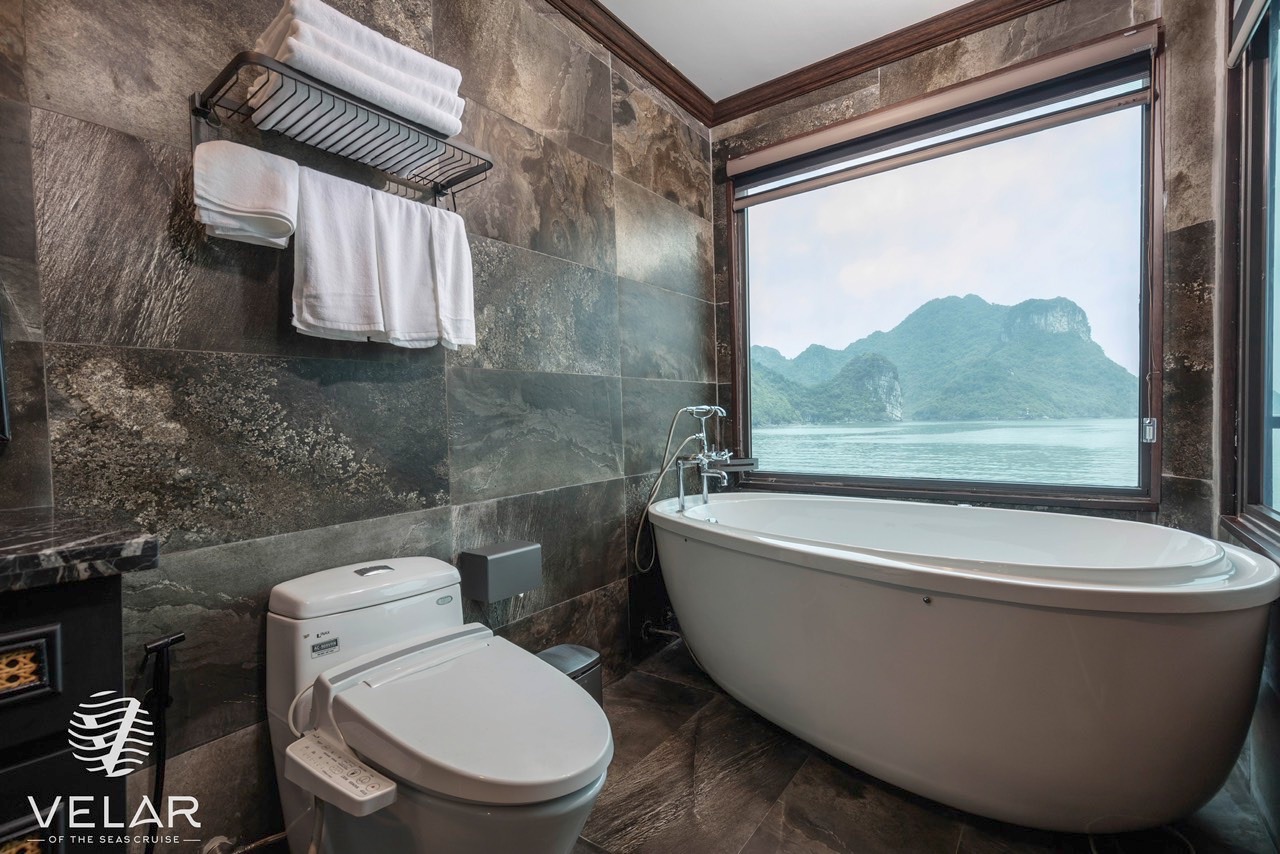 Stunning Halong Bay cruise balcony with mountain views and luxurious bathroom.