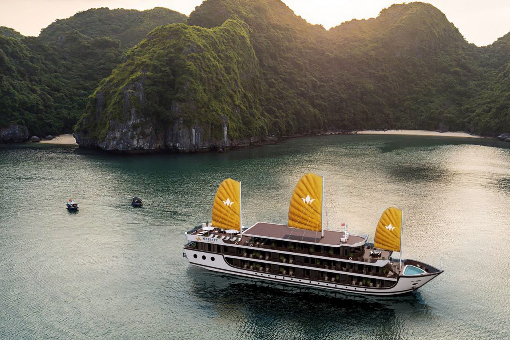 Luxurious cruise boat sailing in Lan Ha Bay with scenic limestone karsts.