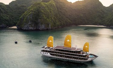 Luxurious cruise boat sailing in Lan Ha Bay with scenic limestone karsts.