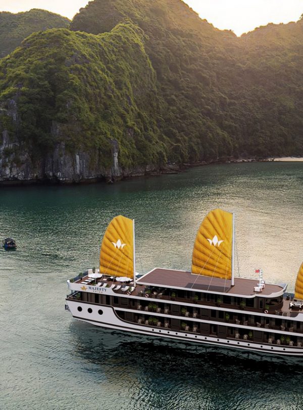 Luxurious cruise boat sailing in Lan Ha Bay with scenic limestone karsts.