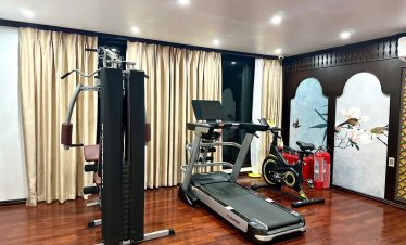 Indoor gym room with modern exercise equipment on Bai Tu Long Cruise.
